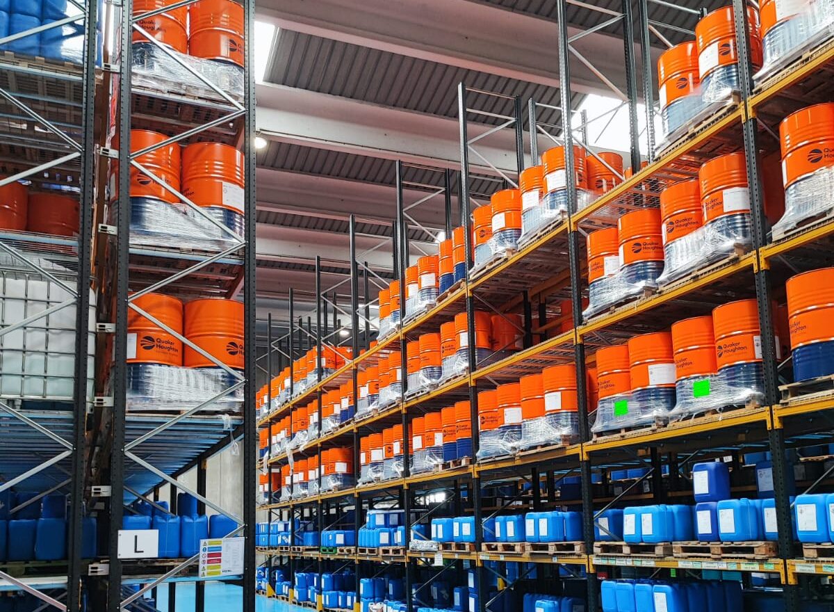 Bodega Quaker Houghton con racks de tambores y bidones de fluidos industriales